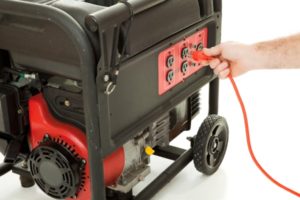 Consumer plugging extension cord into portable generator